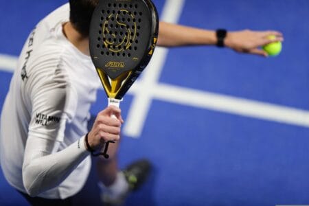LED verlichting padelbaan met speler in actie op blauwe baan